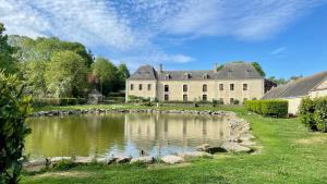 AnctovilleChâteau du Bû的前面有池塘的大房子
