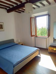 芬奇La casa di Elisa的一间卧室设有蓝色的床和窗户。