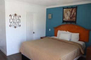 加迪纳市埃多拉多汽车旅馆的一间卧室设有一张床和蓝色的墙壁