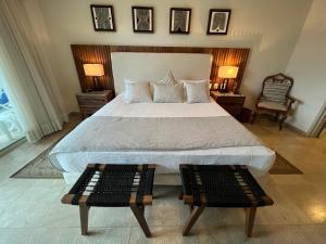 新巴利亚塔Beachfront 2 bedroom Condo in Playa Royale Resort, Nuevo Vallarta的一间卧室配有一张大床和两张桌子