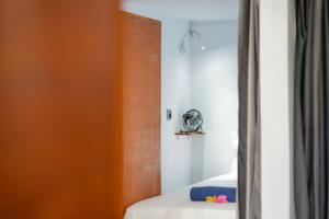 龙目岛库塔Waiwas Hostel的一间卧室配有一张床和镜子