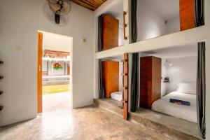 龙目岛库塔Waiwas Hostel的一间设有两张床的客房和一个带门廊的走廊
