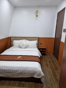 Cao LãnhHotel Trí Lê的卧室配有一张大床,墙上有十字架