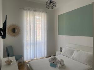 阿拉西奥VERDE Ridi Che Ti Passa的白色的卧室设有床、桌子和窗户