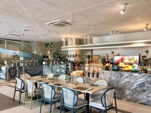 麦克坦Solea Palm Resort Mactan的一间带桌椅和柜台的餐厅