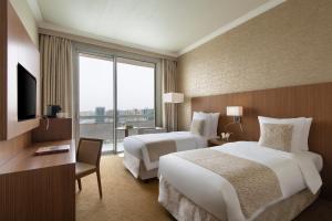 多哈Treffen House Doha - next to Msheireb Metro Station and Souq Waqif的酒店客房设有两张床和大窗户。