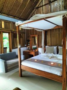 新加拉惹Friendly Homestay Lemukih的一间卧室配有一张带天蓬的大床
