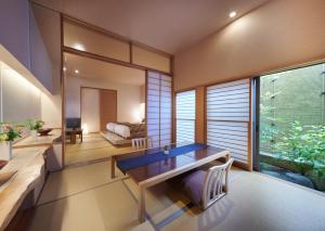 伊豆AKARI et KAORI formerly Taizanso的一间带桌子和大窗户的用餐室