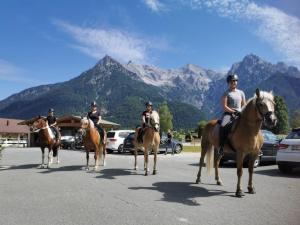 皮勒尔湖畔圣乌尔里希兰德斯特拉瑟维特酒店的一群骑马的人在街上骑着马