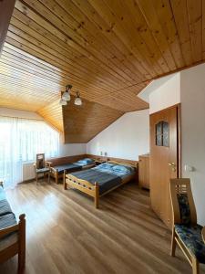 奥斯特罗沃ASIA- Pokoje Gościnne i Studia的一间卧室设有两张床和木制天花板