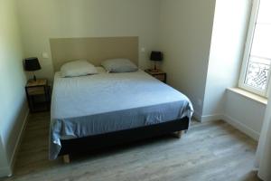 米洛Chez Berni的一间卧室配有带2个床头柜和2个窗户的床