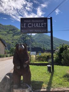 圣玛丽德康庞Hotel Le Chalet的坐在街牌旁的棕色泰迪熊