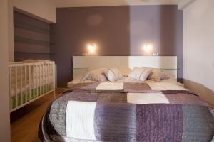 伯德古拉Apartments Glusac的一间卧室配有一张大床和一张婴儿床。