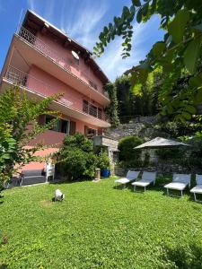内索Giardino sul lago, La Vigna的一个带长椅的院子和粉红色的建筑