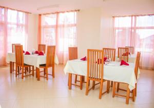 姆特瓦拉Ambiere House的用餐室设有2张桌子和椅子以及窗户。
