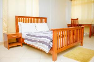 姆特瓦拉Ambiere House的一间卧室配有一张木架床和床头柜
