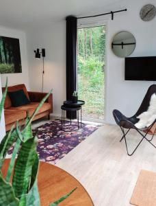 宁斯佩特Luxe Tiny House op de Veluwe的客厅配有沙发和桌子