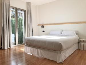 科尔库维翁阿兹霍腾希尔斯酒店的白色的卧室设有床和大窗户