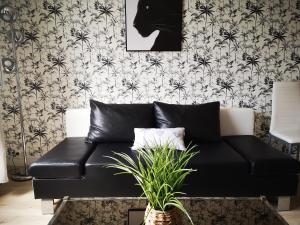 克莱蒙费朗Le Côme - superbe T3 centre-ville avec place de parking Cote Blatin的客厅里一张黑色皮沙发,配有壁纸