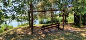 伦蒂萨尔贝基奥加斯特旅馆的坐在湖边树下的公园长椅