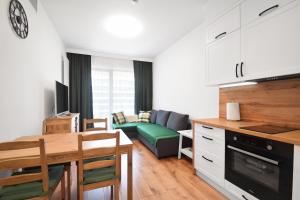 洛格沃Apartament Rogowo的厨房以及带桌子和沙发的客厅。