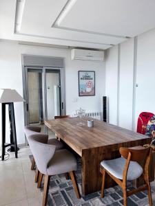 朱拜勒Panoramic Sea View 2 Bedroom Apartment的一间带木桌和椅子的用餐室