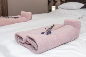 代姆延Ruben Vendégház的床上的粉红色毛巾,上面有葡萄