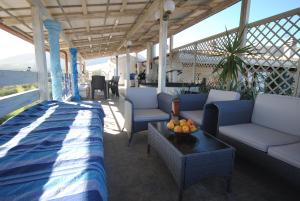 奥罗塞伊Holiday Residence Rifugio的门廊配有沙发和水果桌
