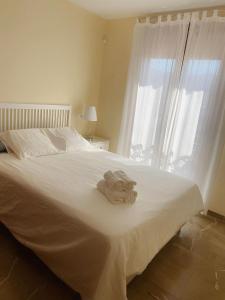 阿尔姆尼卡Lambda LI的卧室配有白色床和毛巾