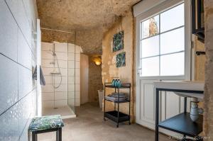 武夫赖La cavée du coteau, petit cocon troglodytique的带淋浴和盥洗盆的浴室以及窗户。