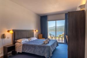 普罗普里亚诺Hotel Hibiscus的酒店客房配有一张床,享有水景