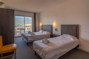 普罗普里亚诺Hotel Hibiscus的酒店客房设有两张床和一个阳台。