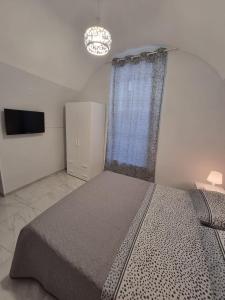 那不勒斯Casa Gio’的一间卧室配有一张大床和电视