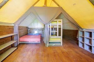 Lamothe-FénelonLa Clairière - écolieu de vacances的帐篷内的卧室,配有床和梯子