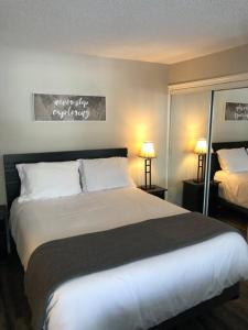 蓝山Freshly Upgraded Cozy Studio @ North Creek Resort的一间卧室配有一张带两盏灯的大型白色床。