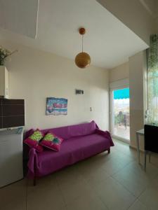 内亚卡瓦里Maria Studio的客厅里设有紫色沙发,配有窗户