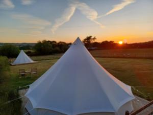 阿贝尔格莱Yr Wyddfa Bell Tent - Pen Cefn Farm, Abergele, Conwy的落日之地的白色帐篷