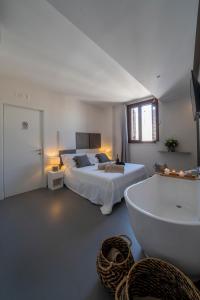 滨海波利尼亚诺Dimora Valmar Luxury Charm的一间卧室配有一张床、一个浴缸和一个浴缸