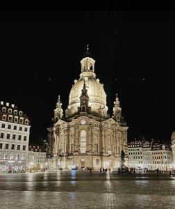 德累斯顿Premium City Appartmartement Dresden Nichtraucher的一座在晚上设有钟楼的大型建筑