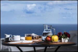 马尔法Il格尔索假期酒店的一张桌子,上面放着一盘水果和一罐果汁