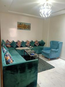 穆罕默迪耶Studio bord de mer Miramar的客厅配有绿色沙发和2把蓝色椅子
