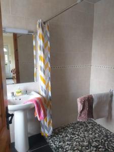 尼纳Dolla的浴室配有盥洗盆和带镜子的淋浴