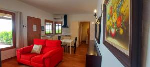 马斯帕洛马斯The Black Horse Canarias - Adults Only的一间带红色沙发的客厅和一间厨房