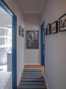 奥比多斯Casa da Travessa - Obidos的一条带蓝色门的走廊,有地毯