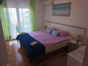 洛夫兰Guesthouse Villa Stanger的一间卧室配有一张大床,配有粉色和蓝色的枕头