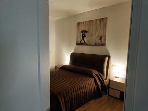 卡利亚里VSuites的卧室配有一张床,墙上挂有绘画作品