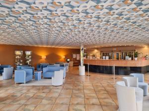 洛阿诺洛阿诺田园酒店的一间设有蓝色椅子和格子天花板的等候室