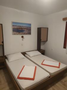诺瓦利娅Apartmani BRUNO的白色墙壁客房的两张床
