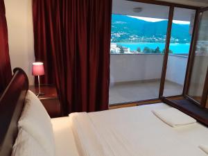 奥赫里德贝拉别墅的一间卧室设有一张床和一个美景窗户。