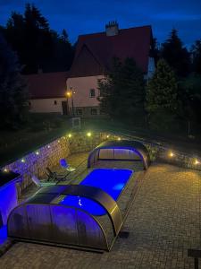 SněžnikResort LUFT Sněžník的游泳池在晚上设有四张四柱床